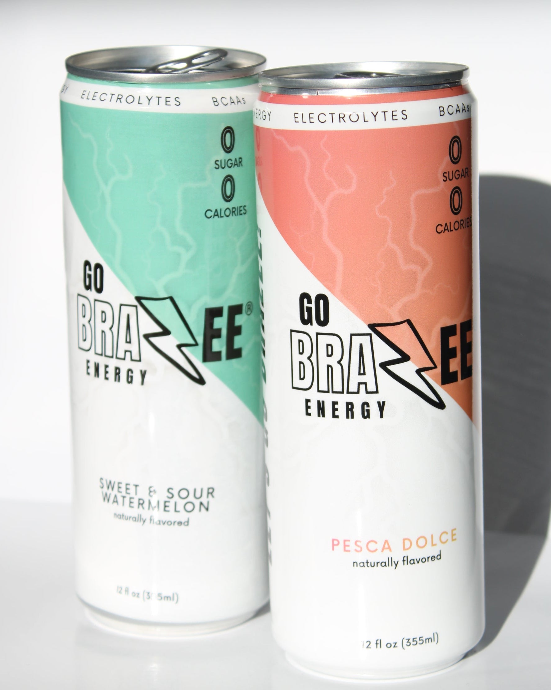 Two cans of Go Brazee Energy drink on a reflective surface